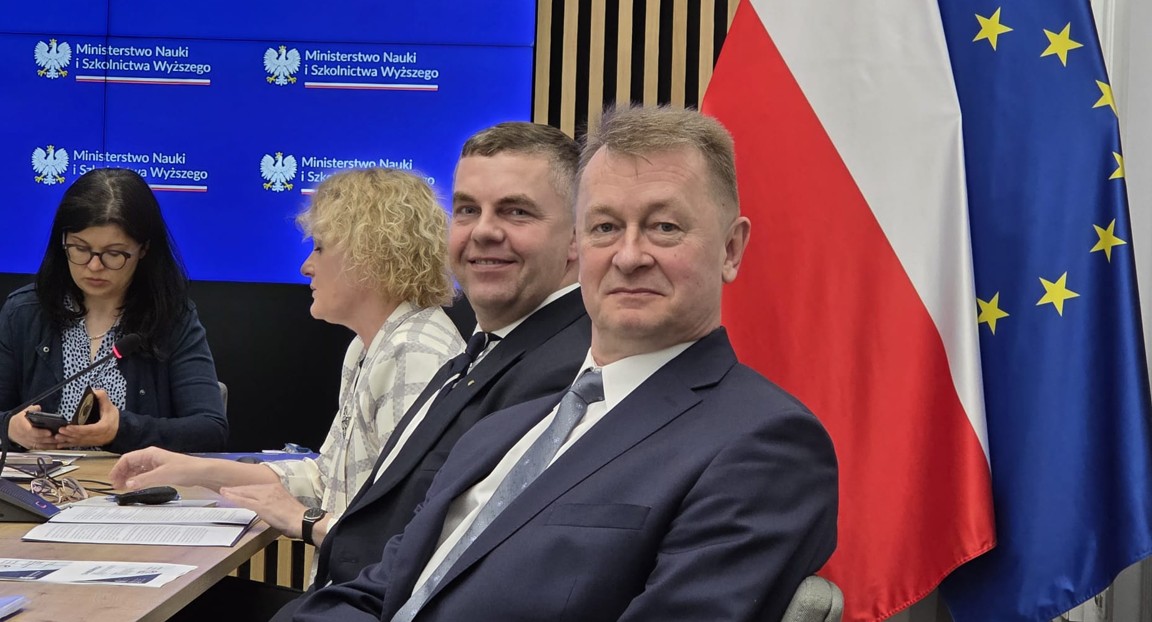 zdjęcie rektora na tle flag
